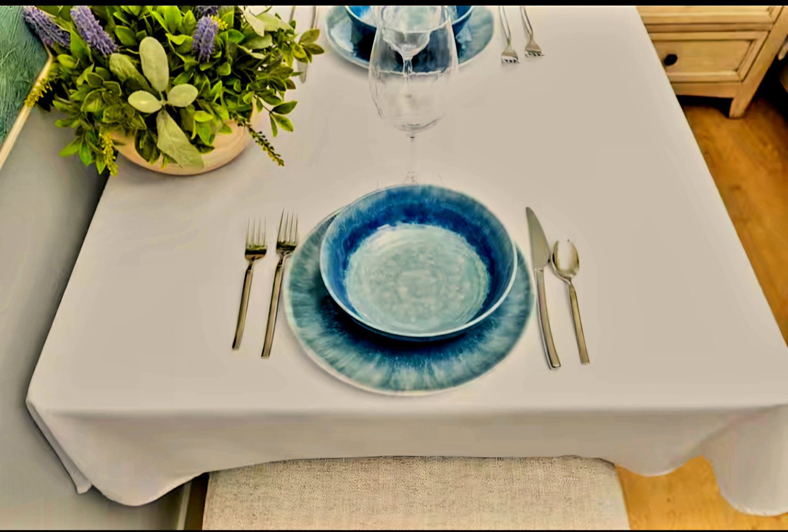Artisan blue table setting with wine glasses and floral centerpiece